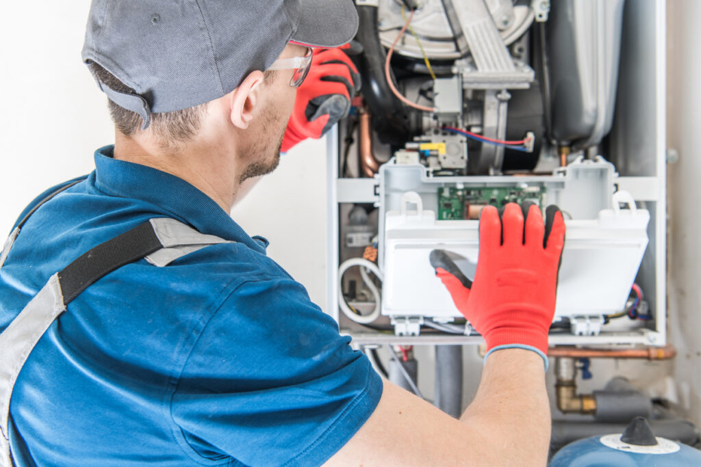 A technician repairing a furnace